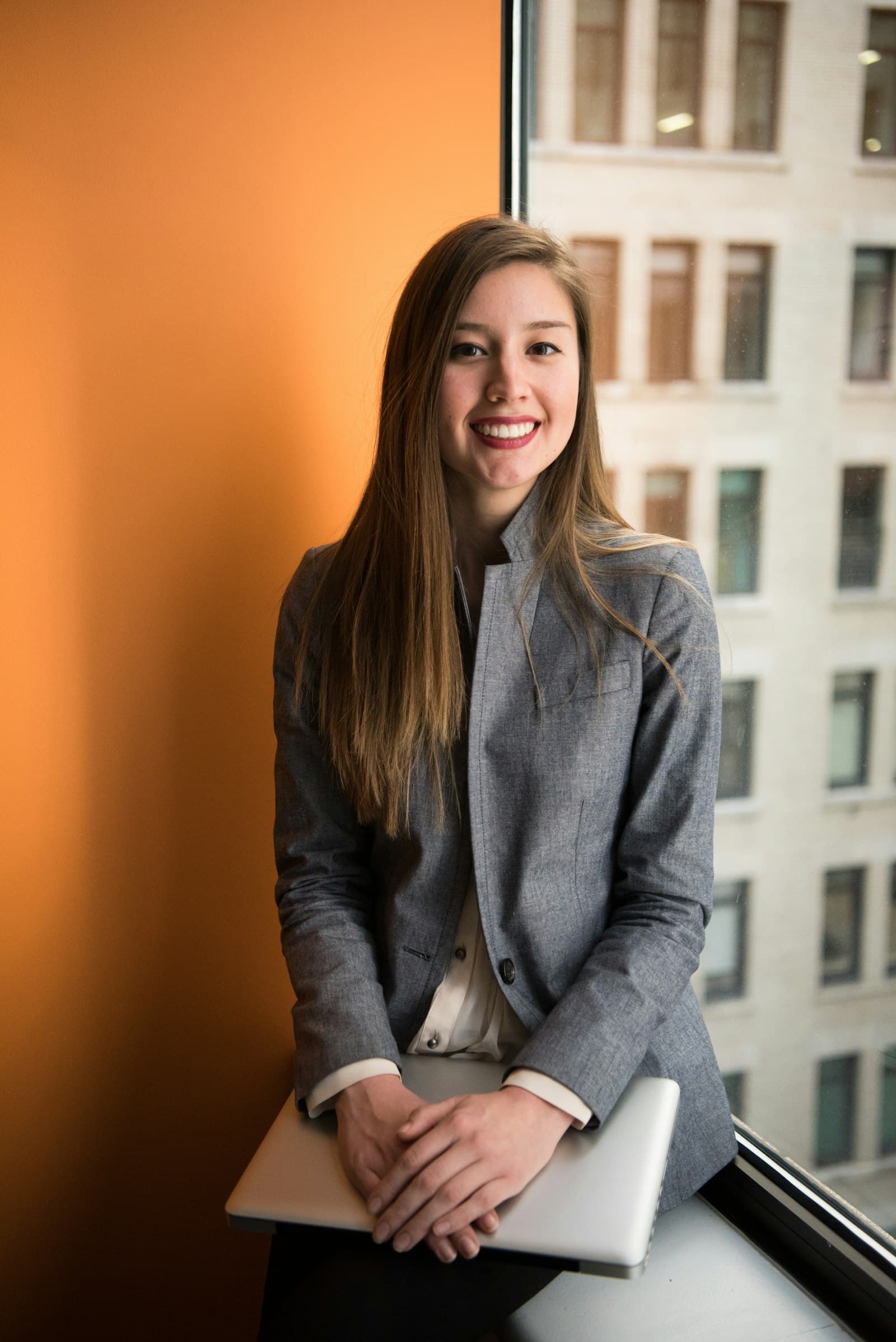 Smiling woman in a gray blazer, professional portrait